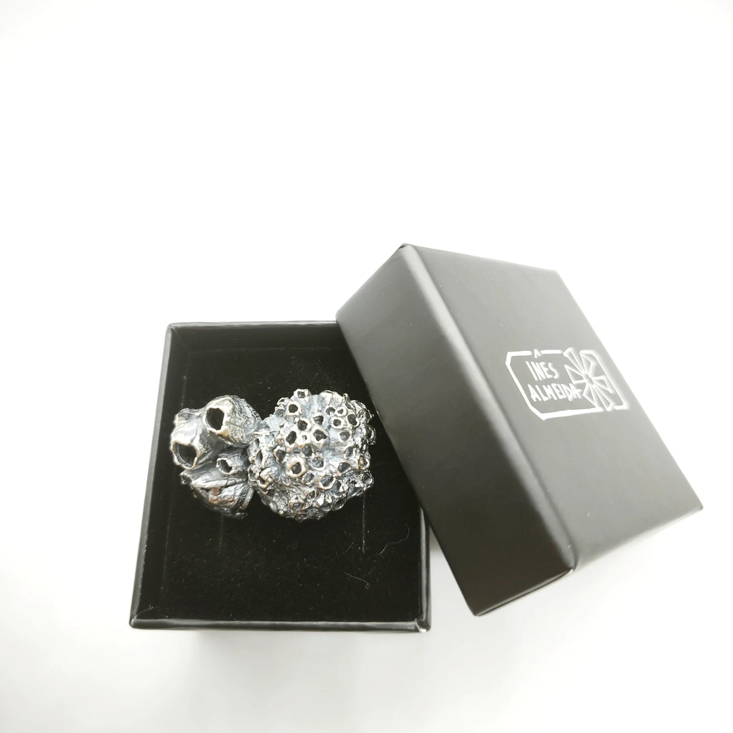 925 sterling oxidised silver brooch with the texture from a barnacle in a jewellery bacl box. Design by Inês Almeida