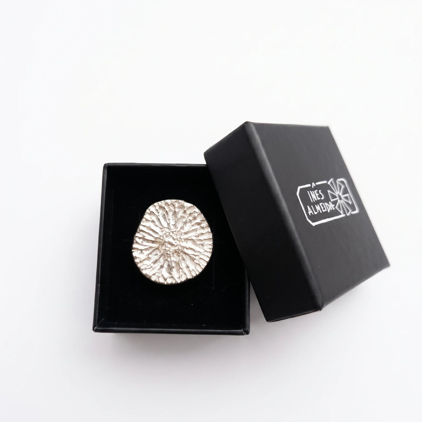 925 sterling silver ring with the texture from a dolphin bone in a black jewellery box. Design by Inês Almeida