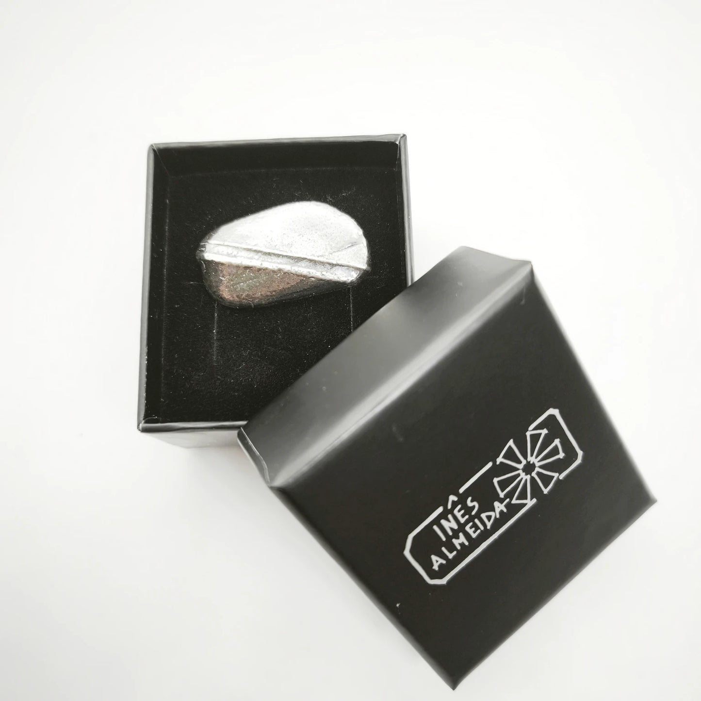 925 sterling silver oxidised ring with the texture from small pebble in a jewellery black box. Design by Inês Almeida