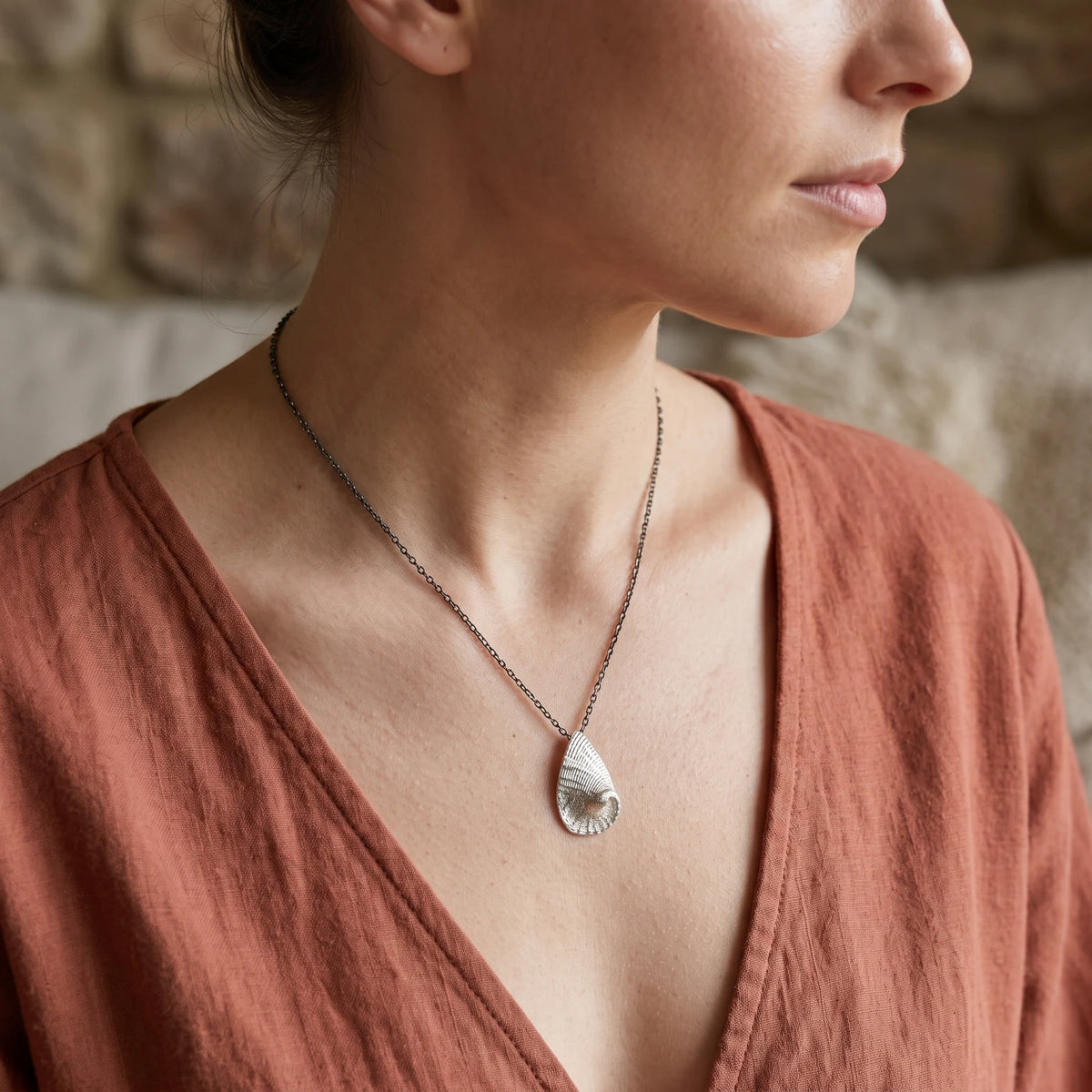 Woman wearing a 925 sterling silver pendent with the texture from a Fragment of an abalone. Design by Inês Almeida