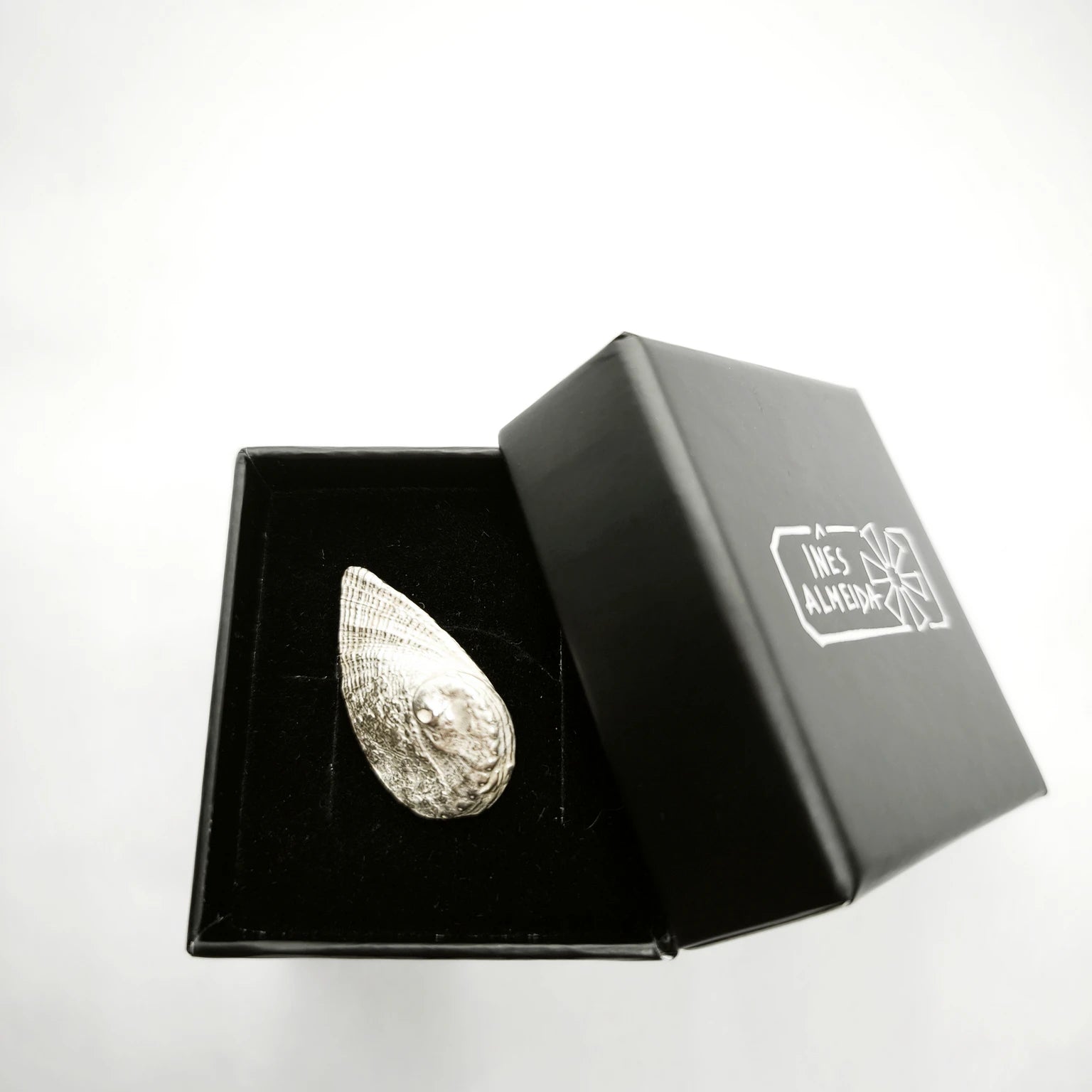 925 sterling silver pendent with the texture from a Fragment of an abalone in a jewellery black box. Design by Inês Almeida