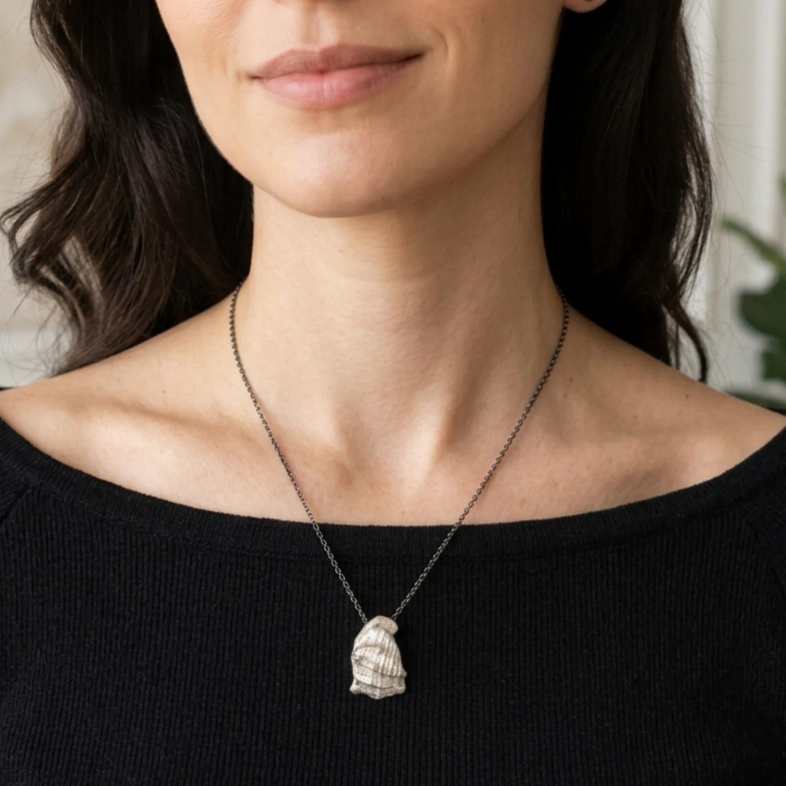 Woman wearing a 925 sterling silver pendant with the texture from a conch shell. Design by Inês Almeida