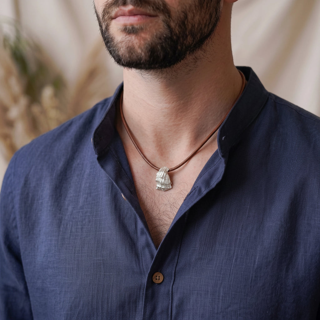 Man wearing a 925 sterling silver pendant with the texture from a conch shell. Design by Inês Almeida 