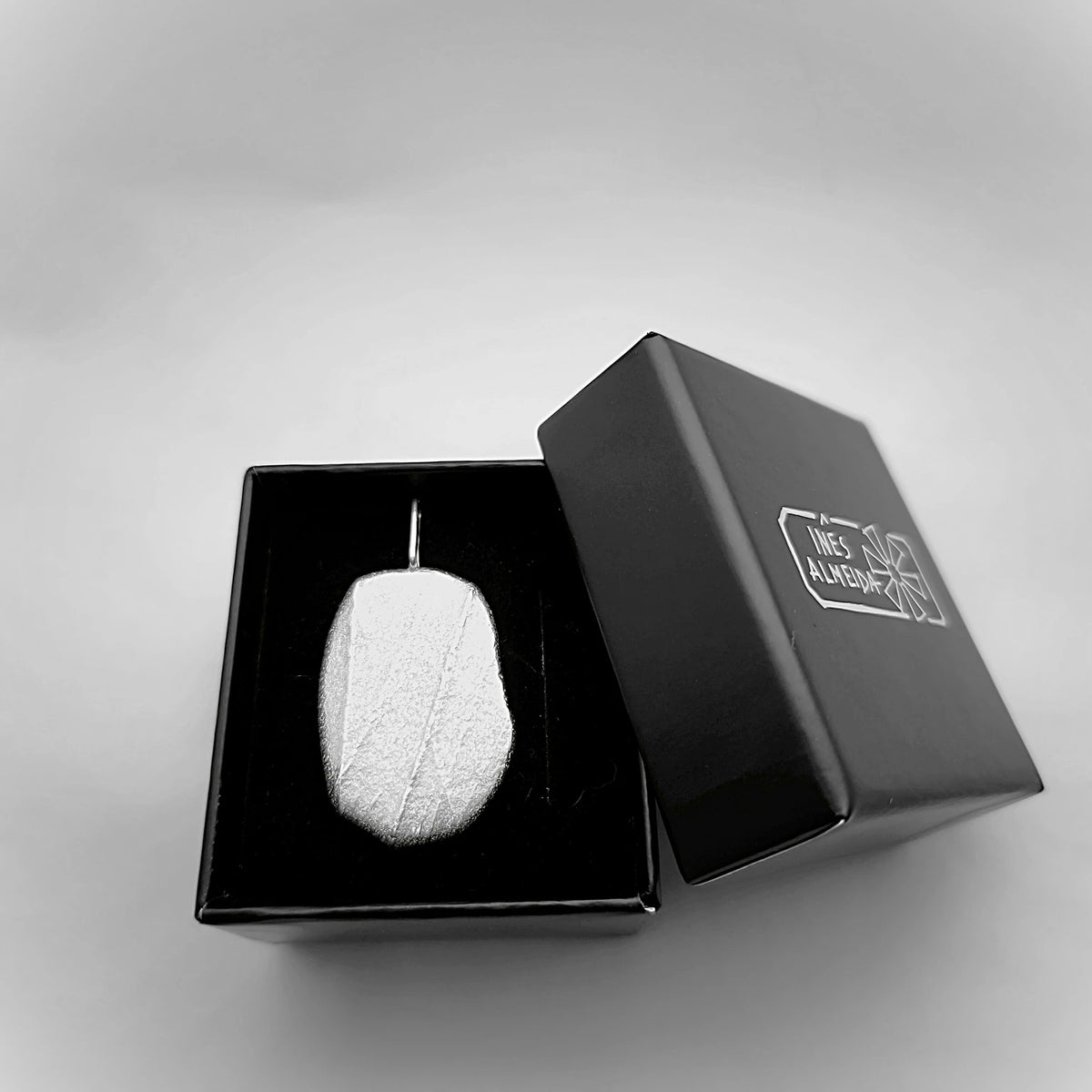 925 sterling silver pendant with the texture from a pebble in a jewellery back box. Design by Inês Almeida