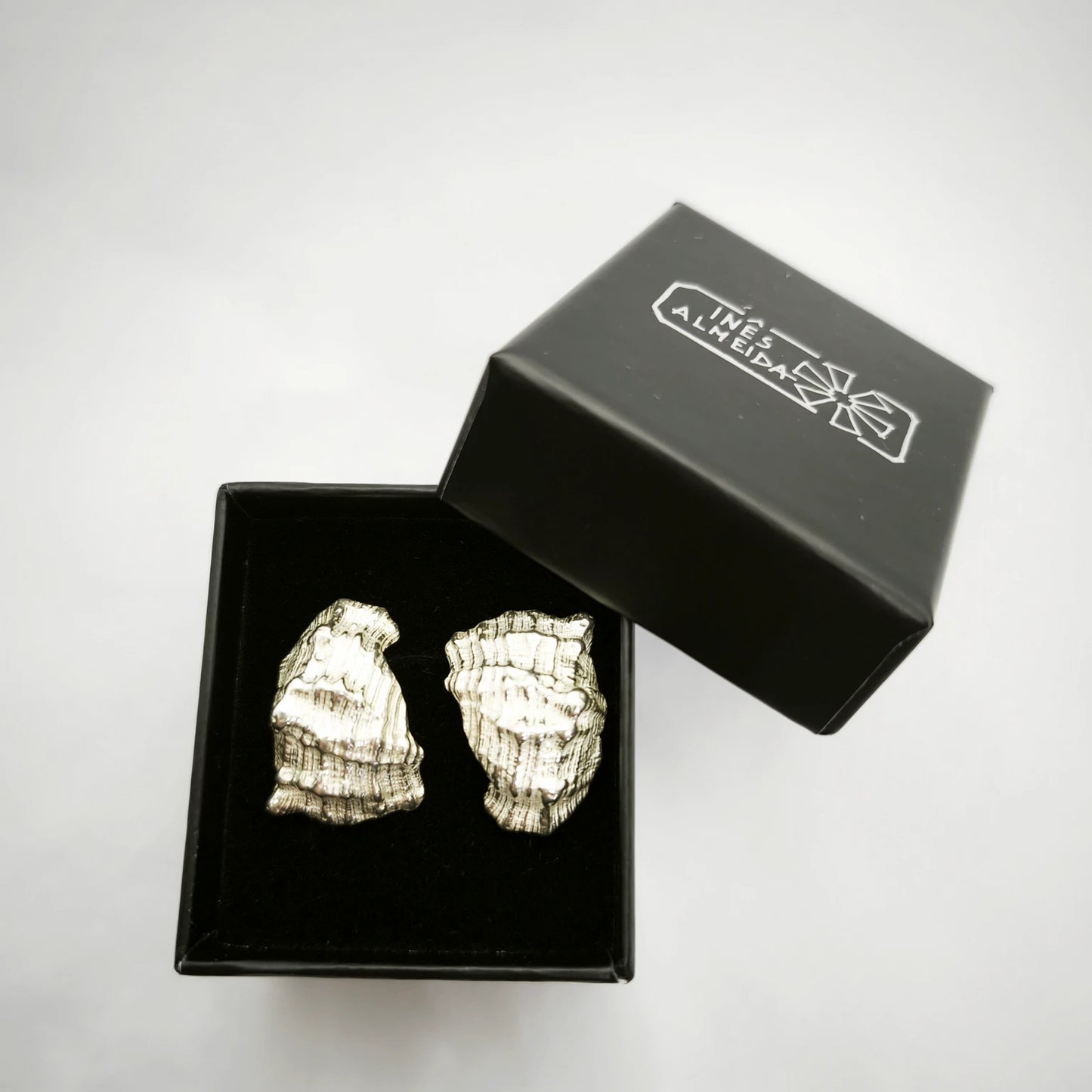 925 sterling silver earrings with the texture from a conch shell in a black jewellery box. Design by Inês Almeida