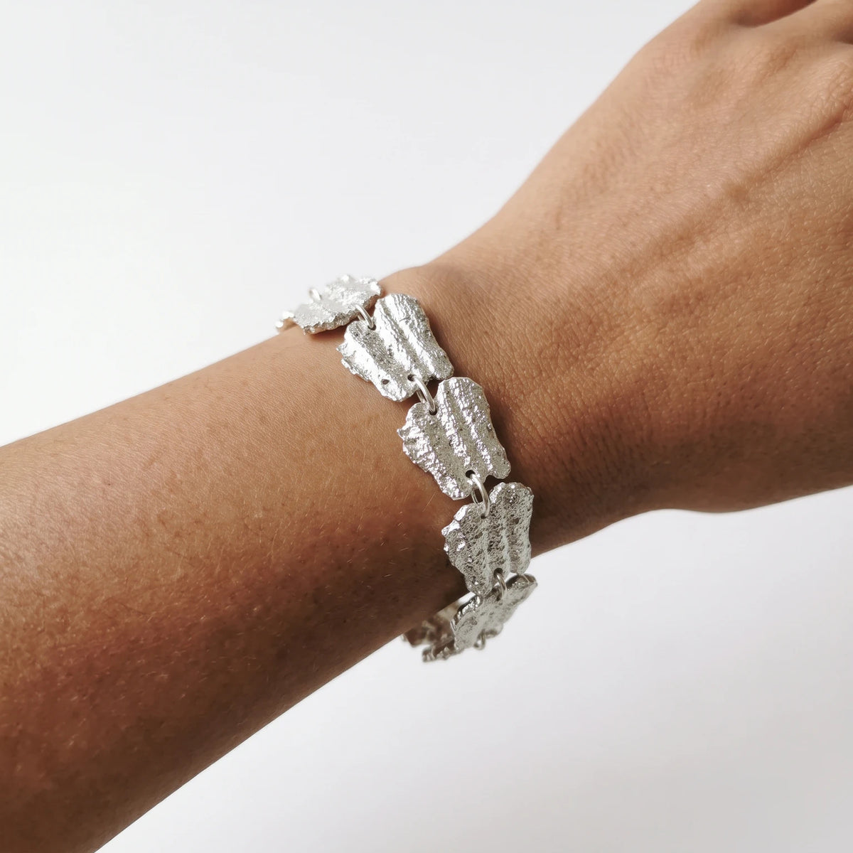 Woman wearing a 925 sterling silver bracelet with the textures from shell fragments. Design by Inês Almeida