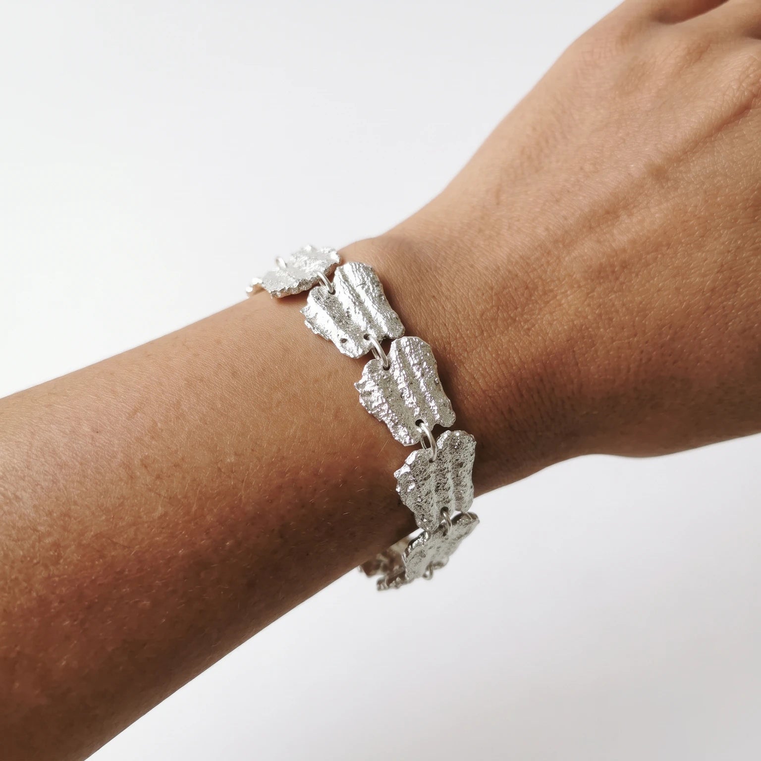 Woman wearing a 925 sterling silver bracelet with the textures from shell fragments. Design by Inês Almeida
