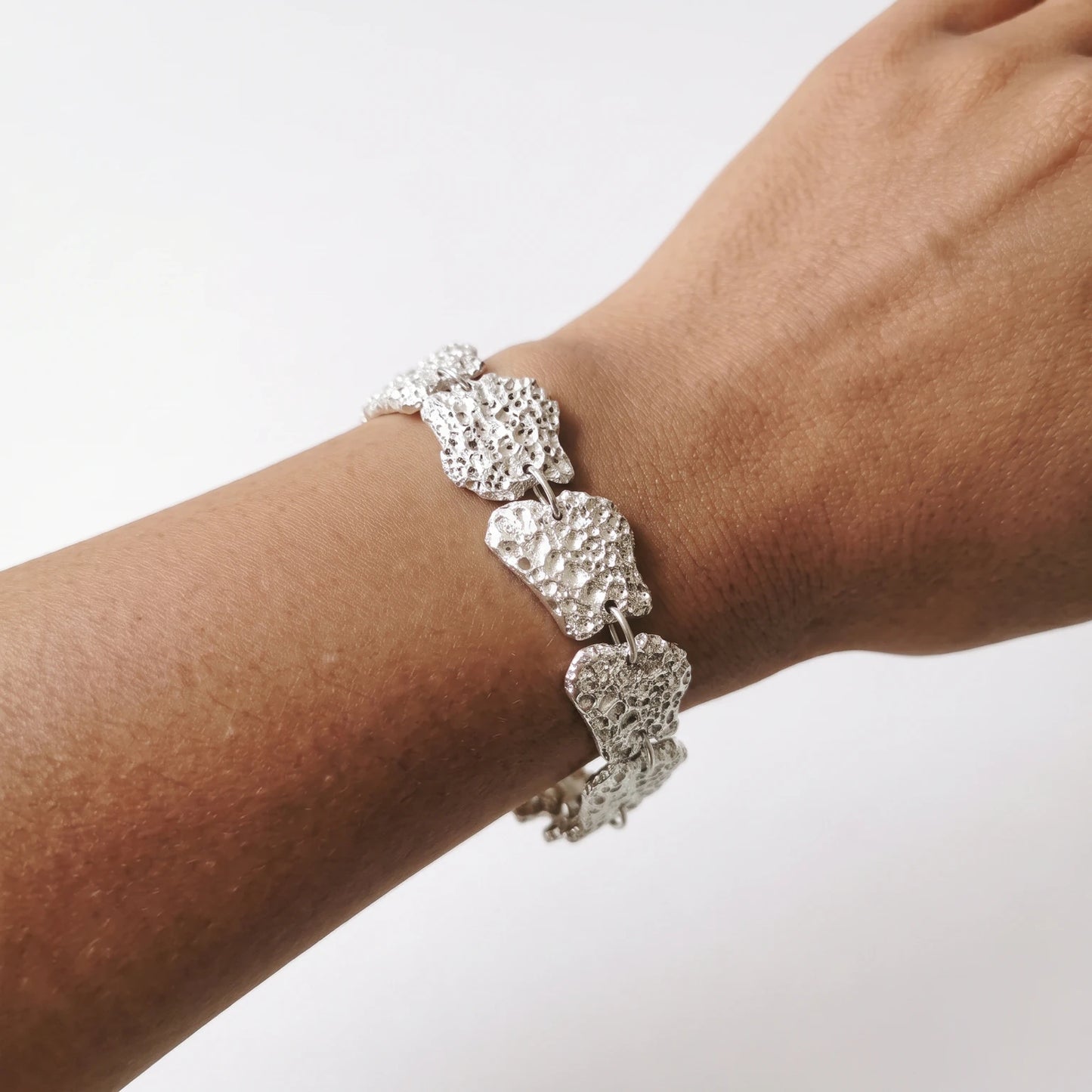 Woman wearing a 925 sterling silver bracelet with the textures from shell fragments. Design by Inês Almeida
