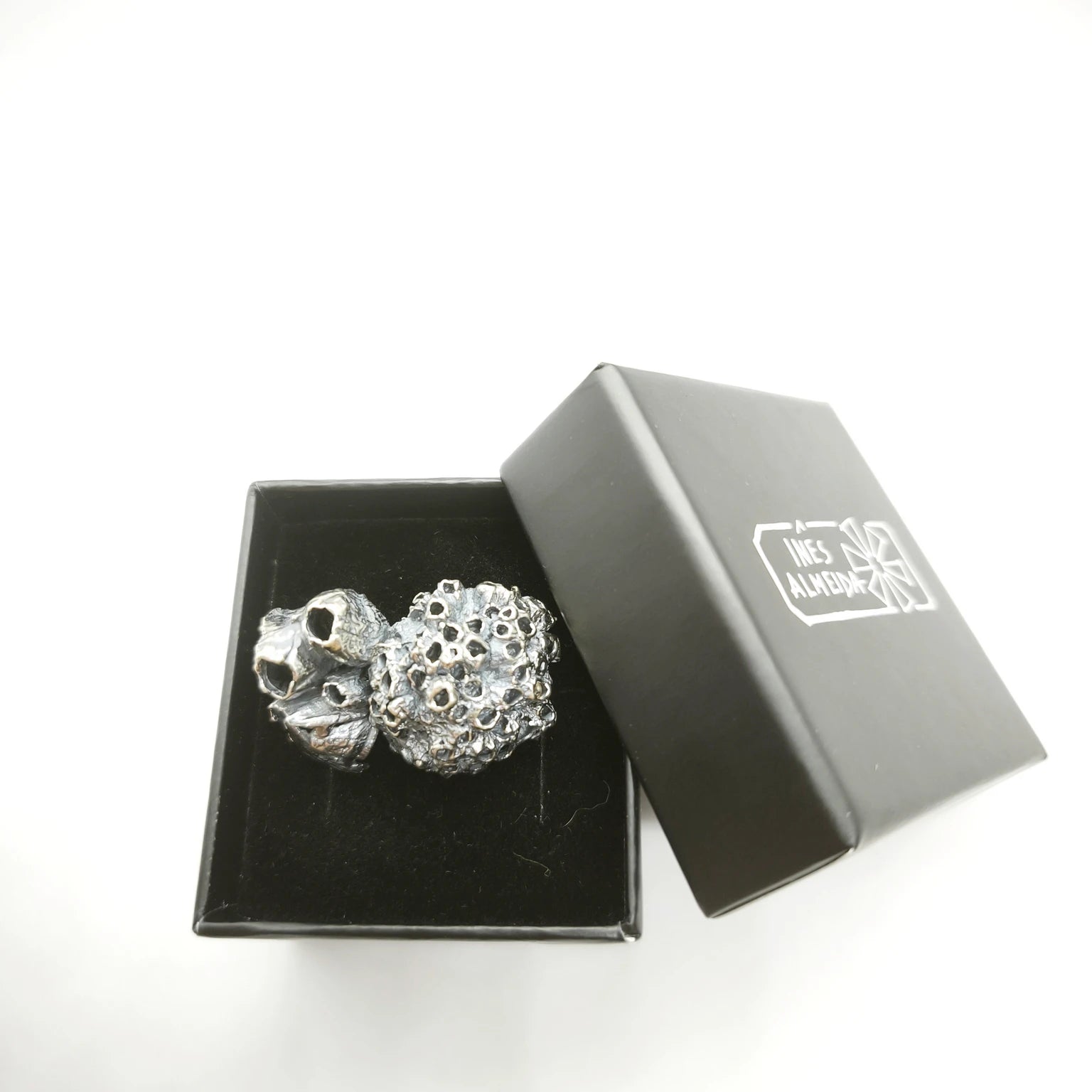 925 sterling oxidised silver brooch with the texture from a barnacle in a jewellery bacl box. Design by Inês Almeida