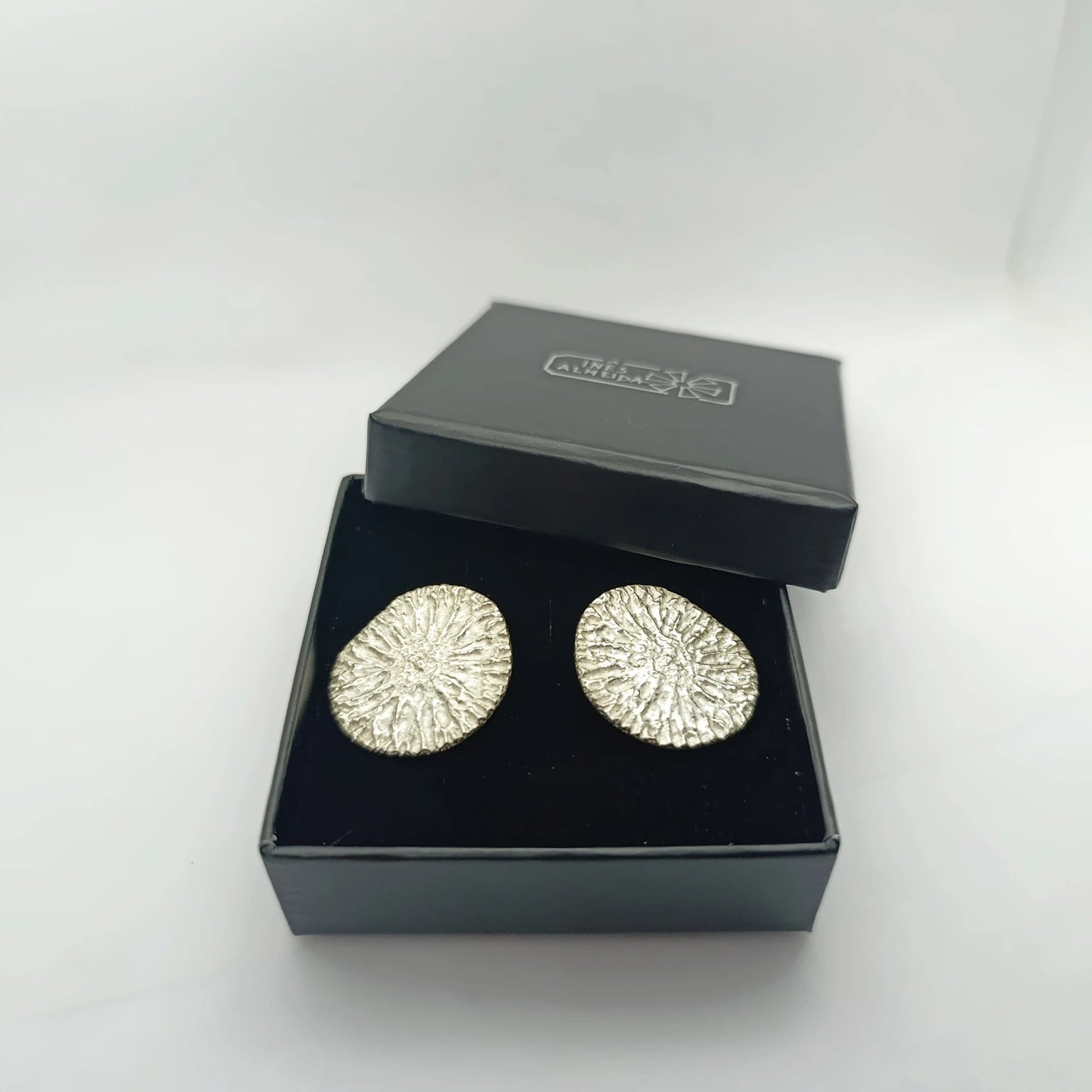 925 sterling silver earrings with the texture from a dolphin spine bone, in a jewellery box. Design by Inês Almeida,