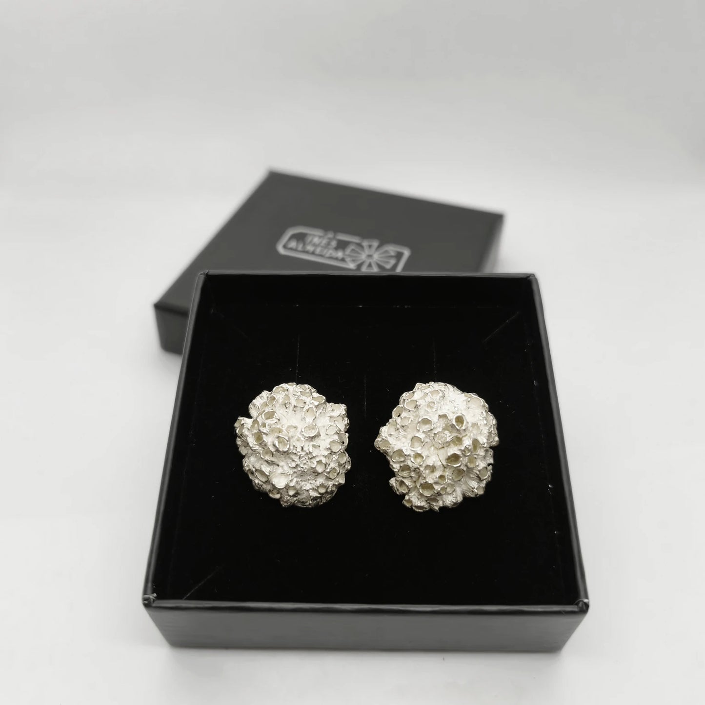 Handcrafted 925 sterling silver earrings with organic texture inspired by marine barnacles, set in the jewellery box. Piece by Inês Almeida Jewellery