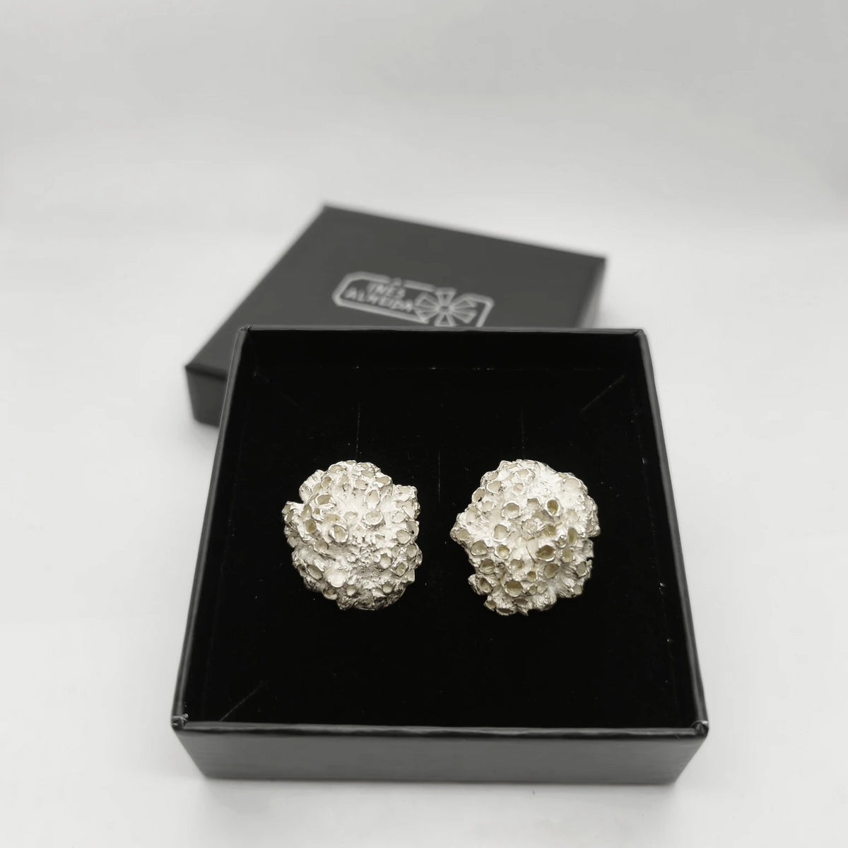 Handcrafted 925 sterling silver earrings with organic texture inspired by marine barnacles, set in the jewellery box. Piece by Inês Almeida Jewellery