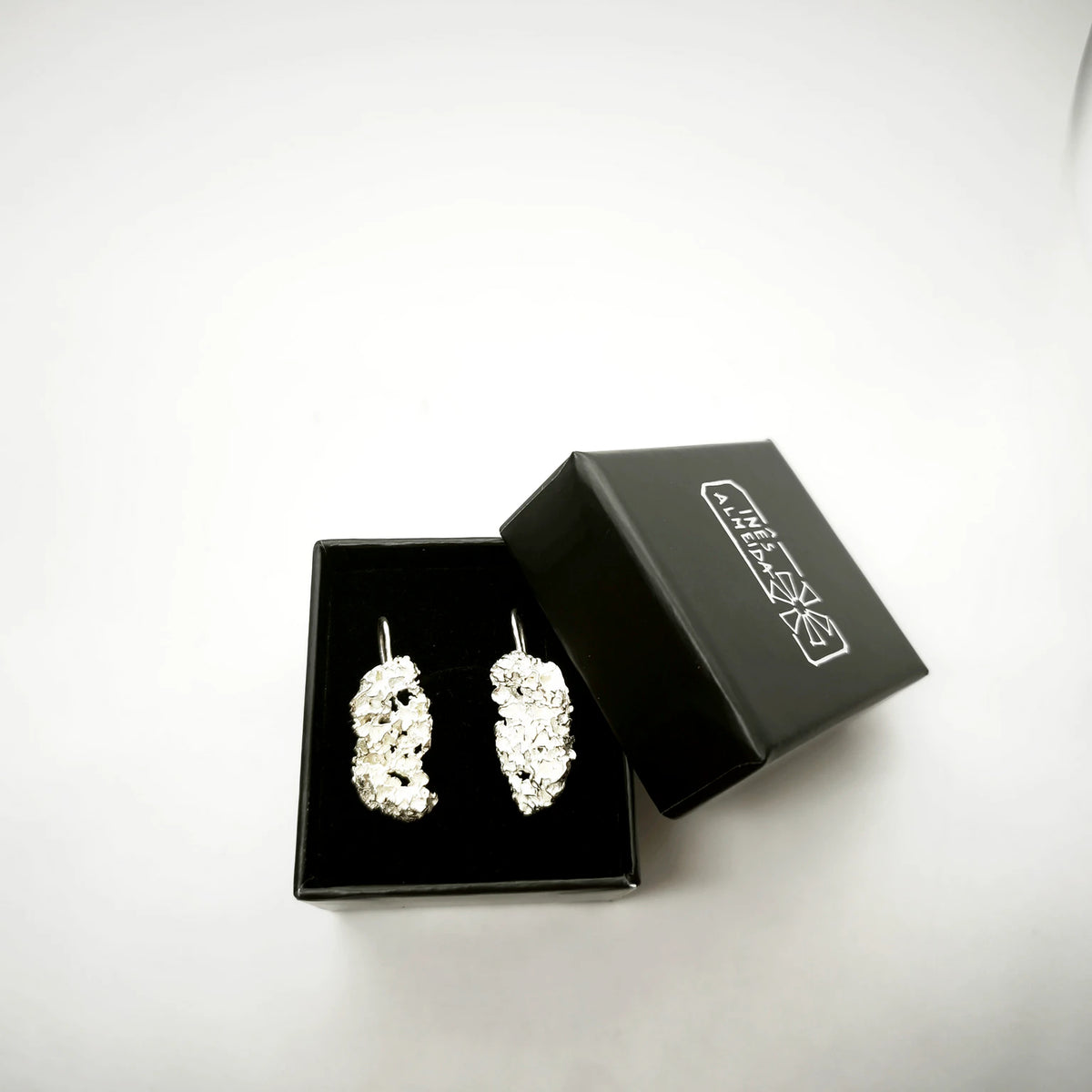 925 sterling silver earrings with the texture from a coraline in a black jewellery box. Design by Inês Almeida