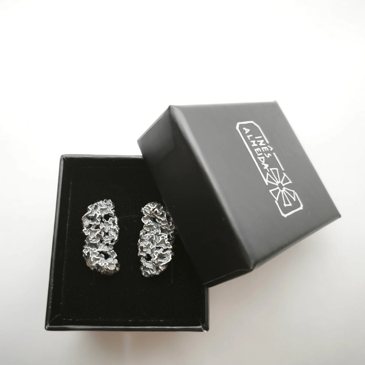 925 sterling oxidised silver earrings with the texture from a coraline in a black jewellery box. Design by Inês Almeida