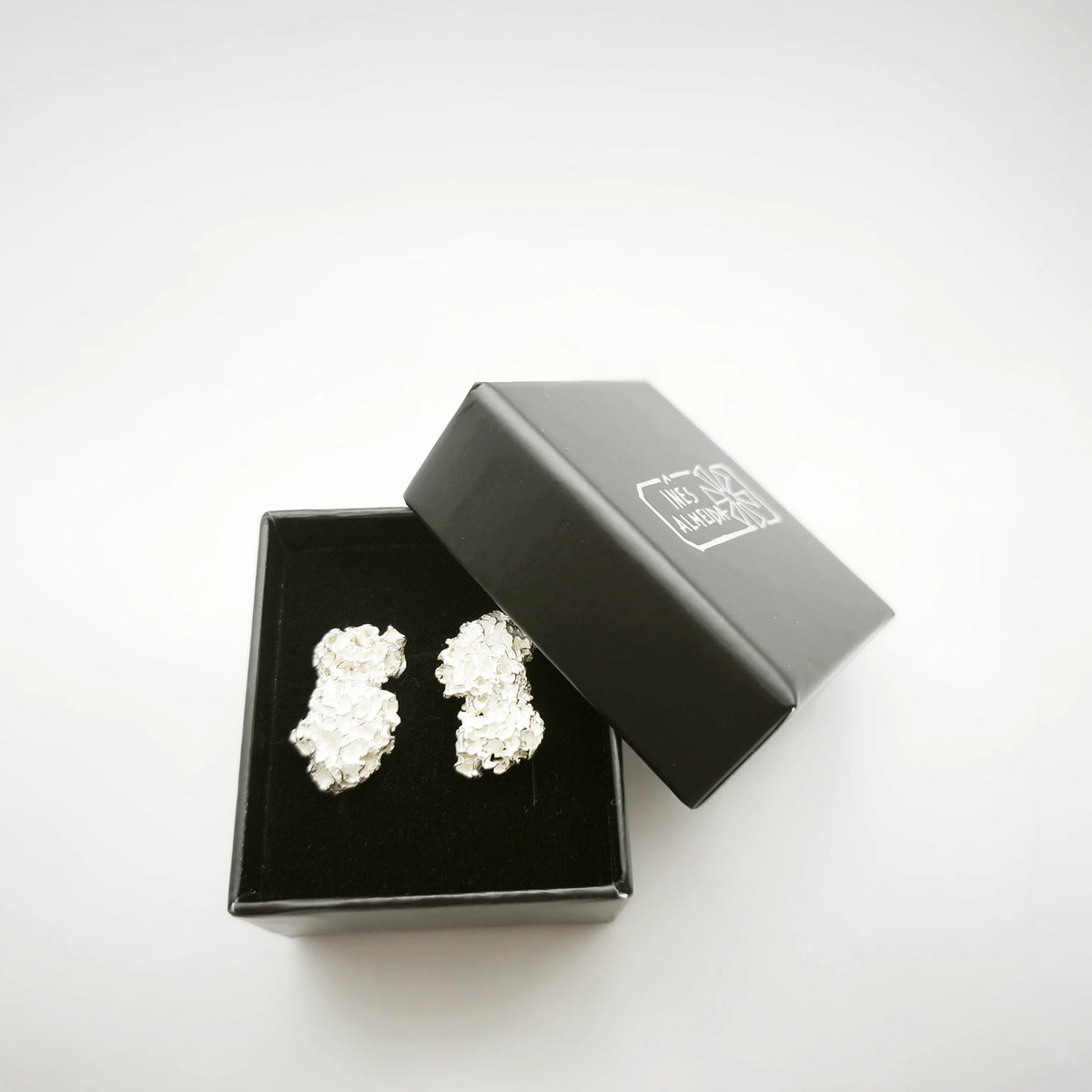 925 sterling silver earrings with the texture from a coraline in a black jewellery box. Design by Inês Almeida