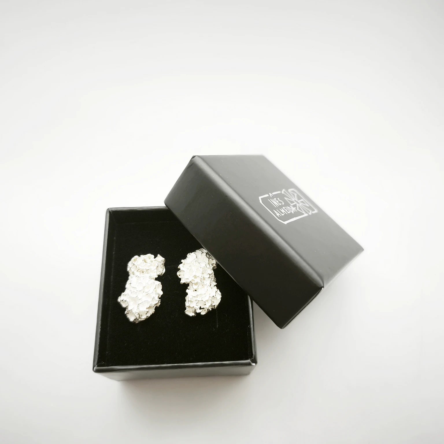 925 sterling silver earrings with the texture from a coraline in a black jewellery box. Design by Inês Almeida