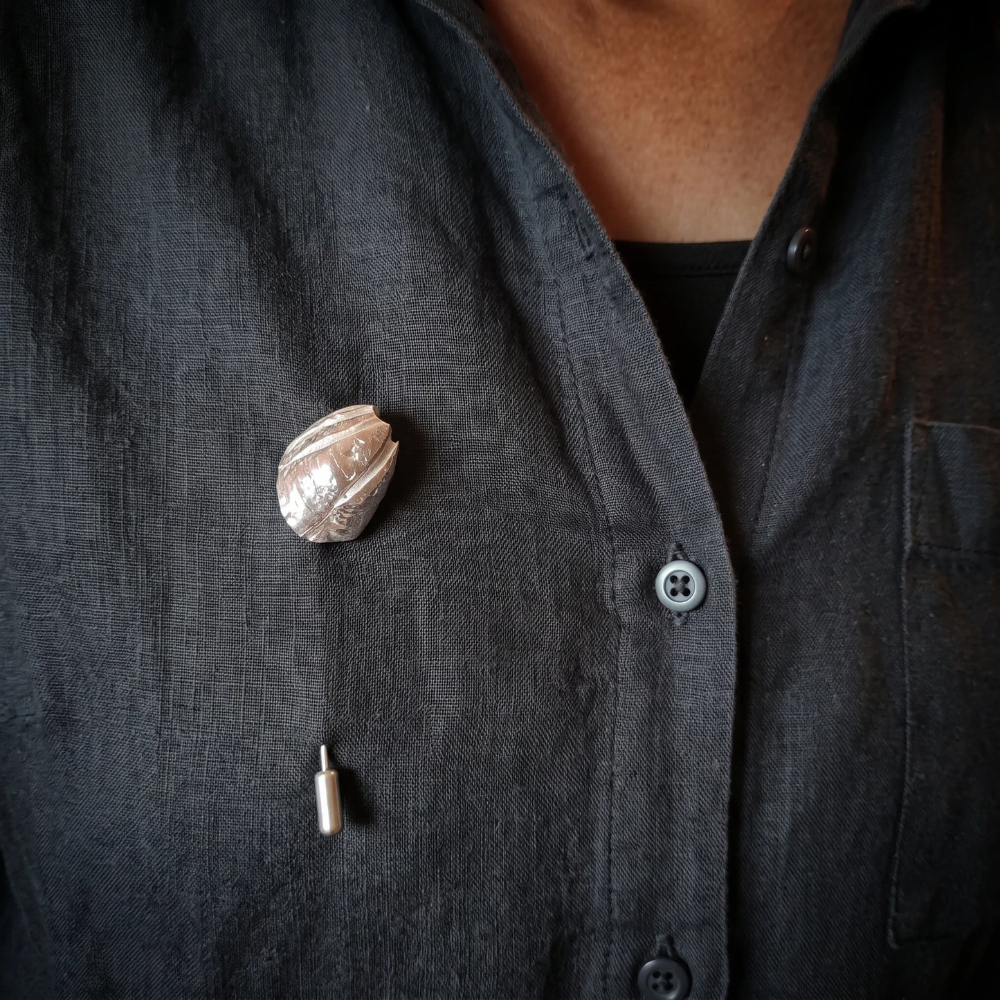 Woman wearing a 925 sterling silver pin with the texture from a barnacle. Design by Inês Almeida