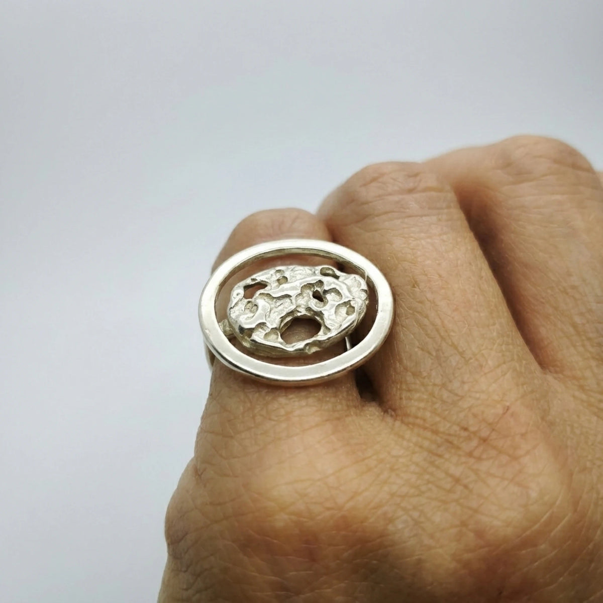 woman wearing a 925 sterling silver ring with the texture from a conch shell. Design by Inês Almeida