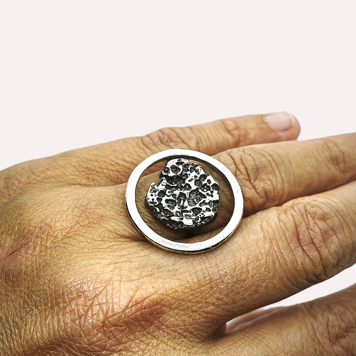 woman wearing a 925 sterling silver ring oxidised with the texture from a conch shell. Design by Inês Almeida