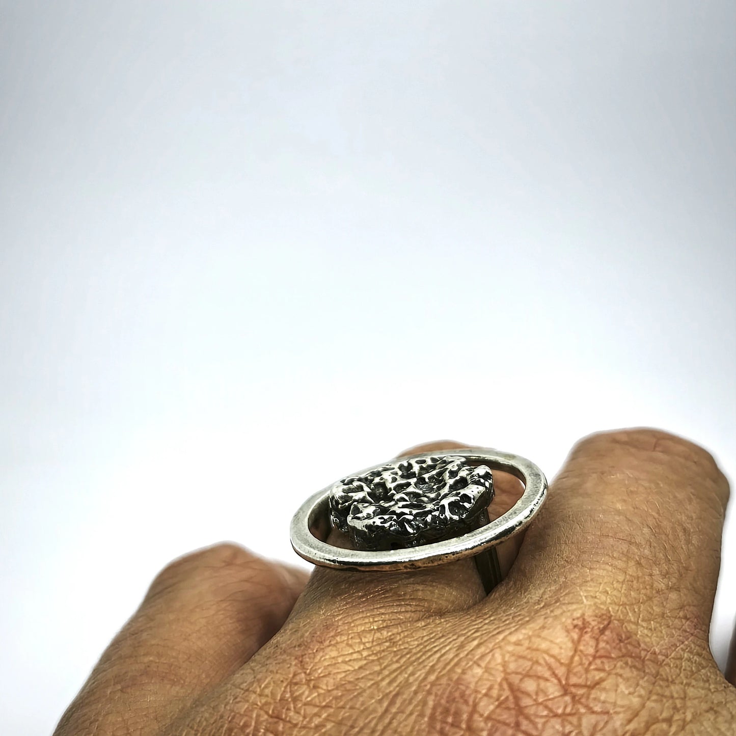 woman wearing a 925 sterling silver ring oxidised with the texture from a conch shell. Design by Inês Almeida