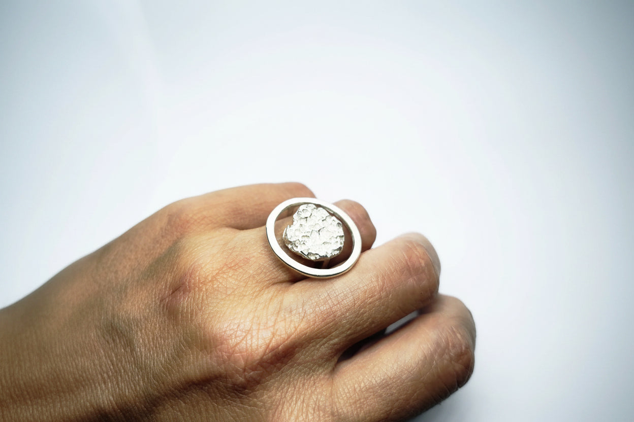 Woman wearing a 925 sterling silver ring with the texture from a rock fragment. Design by Inês Almeida