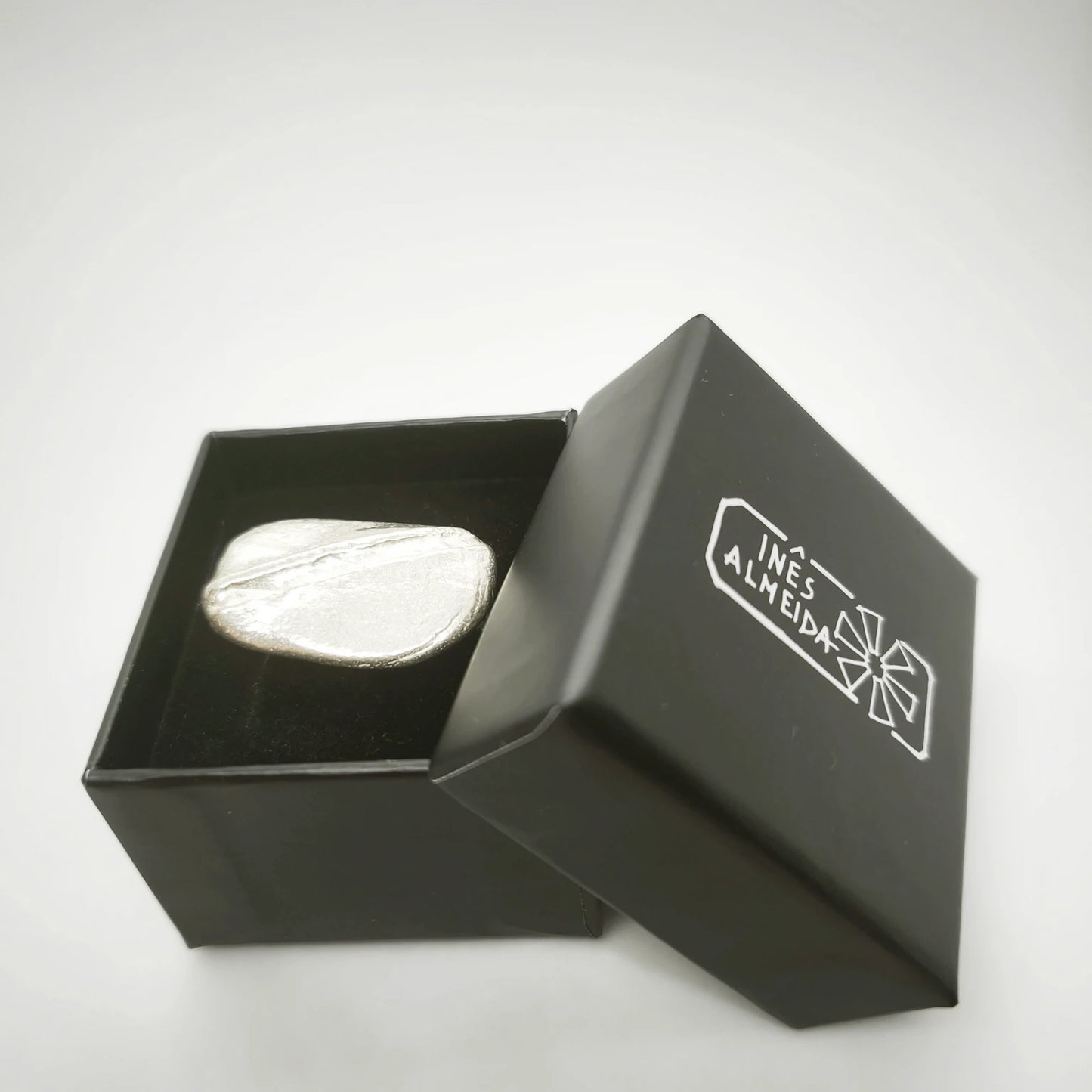 925 sterling silver ring with the texture from a pebble in a jewellery back box. Design by Inês Almeida