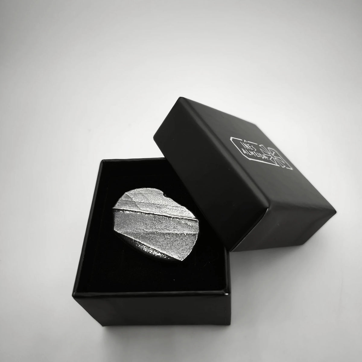 925 sterling silver oxidised ring with the texture from small pebble in a jewellery black box. Design by Inês Almeida