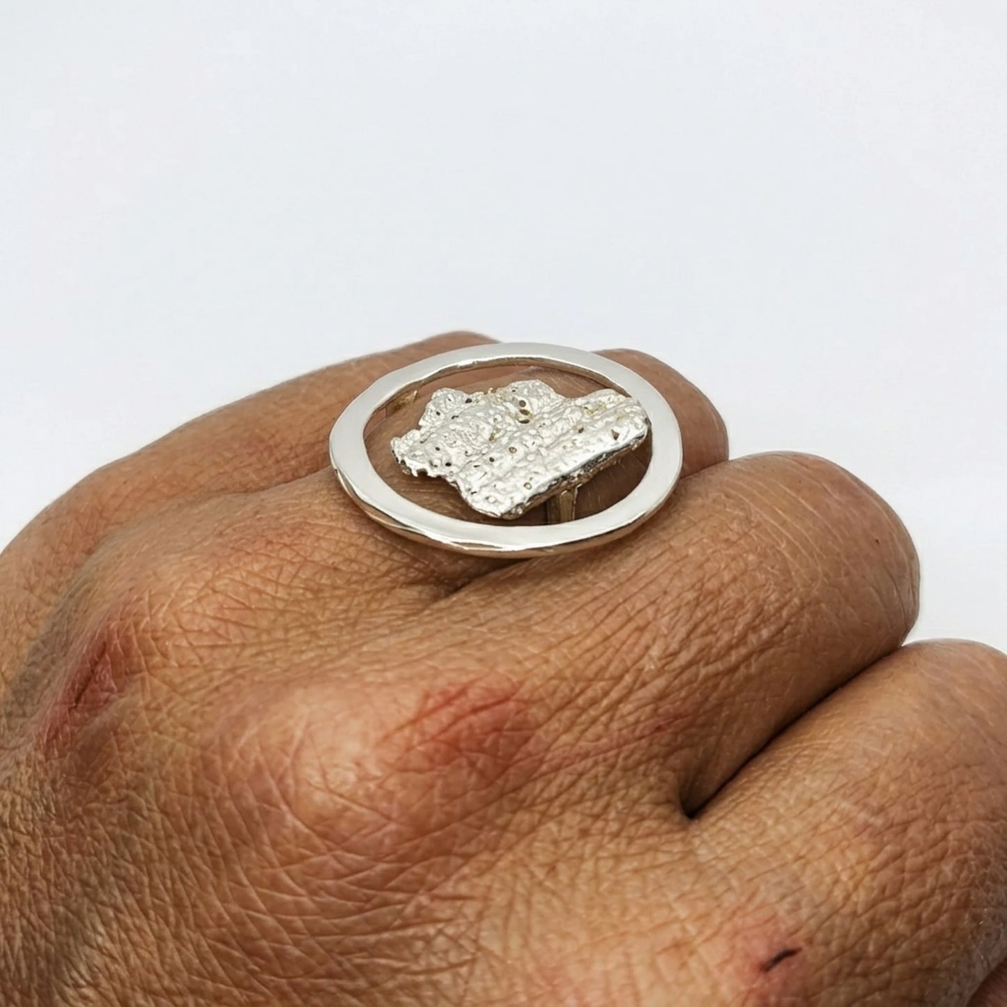 Women wearing a 925 sterling silver ring with the texture from a shell. Design by Inês Almeida