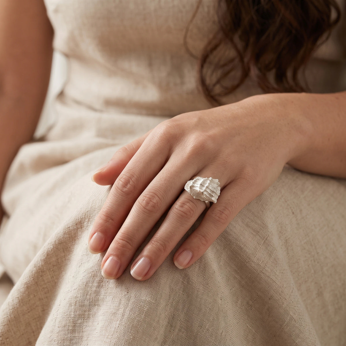 woman wearing a 925 sterling silver ring with the texture from a conch shell. Design by Inês Almeida