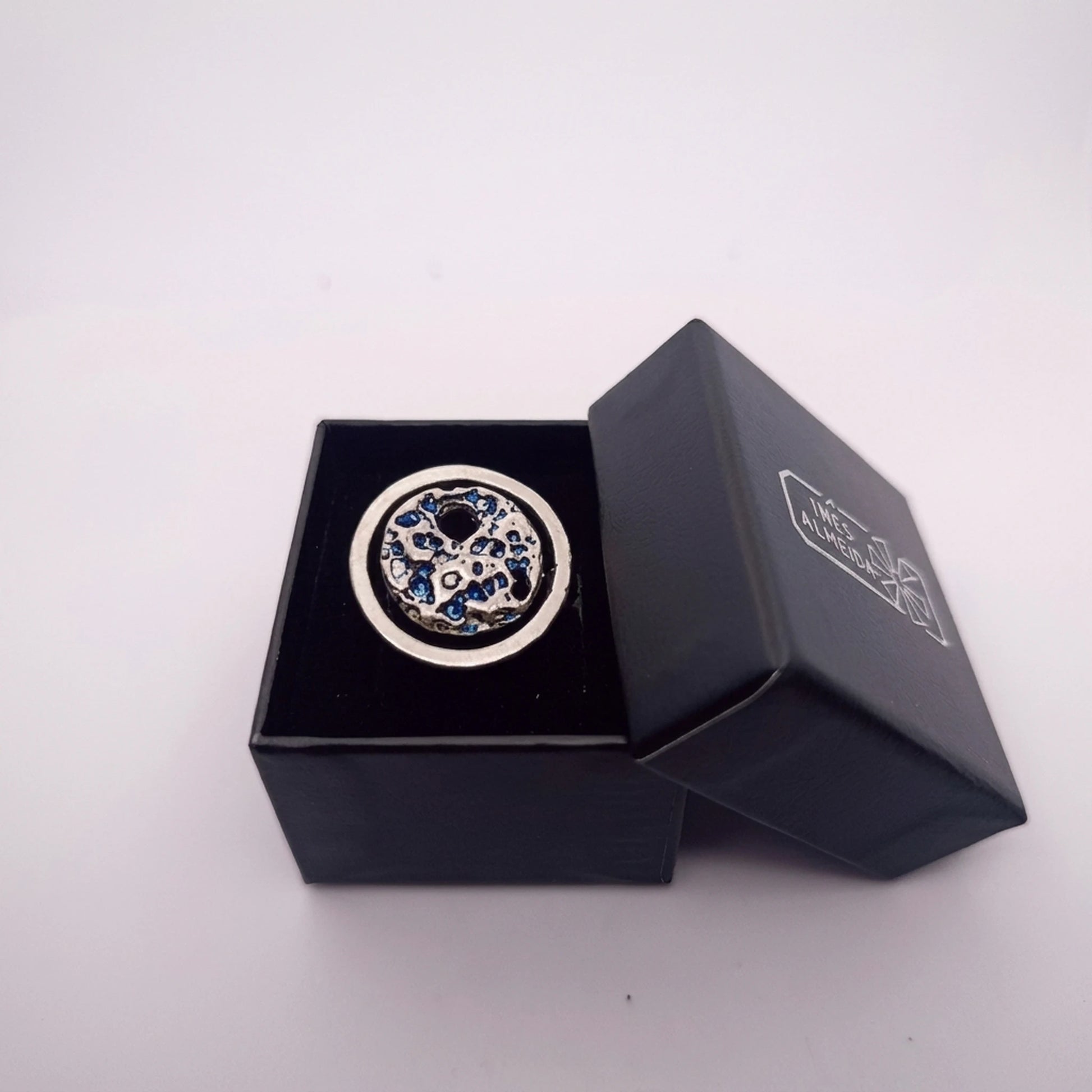 925 sterling silver blue ring with the texture from a conch in a open black jewellery box. Design by Inês Almeida