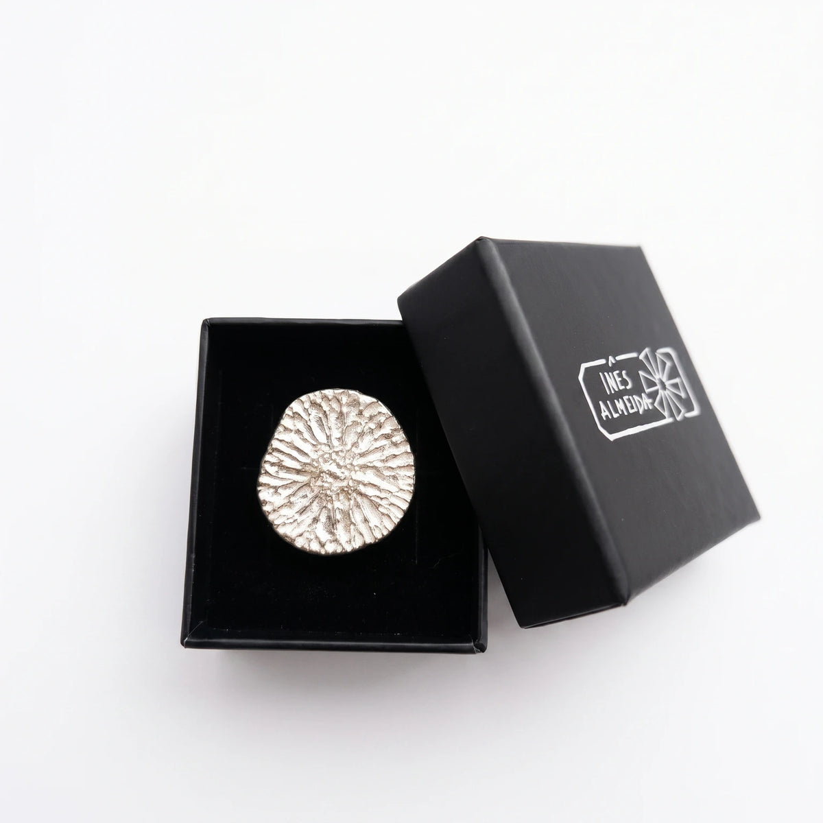 925 sterling silver ring with the texture from a dolphin bone in a black jewellery box. Design by Inês Almeida