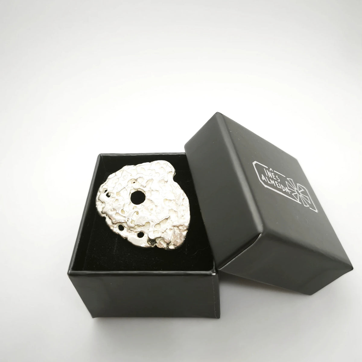 925 sterling silver ring with the texture a from pebble in a jewellery back box. Design by Inês Almeida
