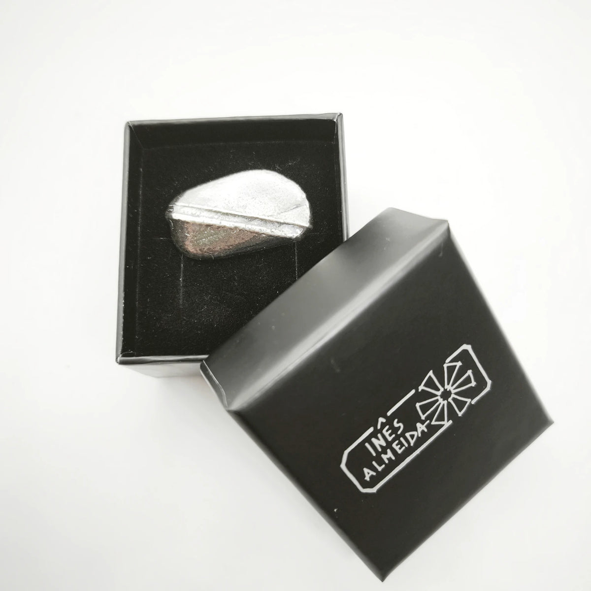 925 sterling silver oxidised ring with the texture from small pebble in a jewellery black box. Design by Inês Almeida