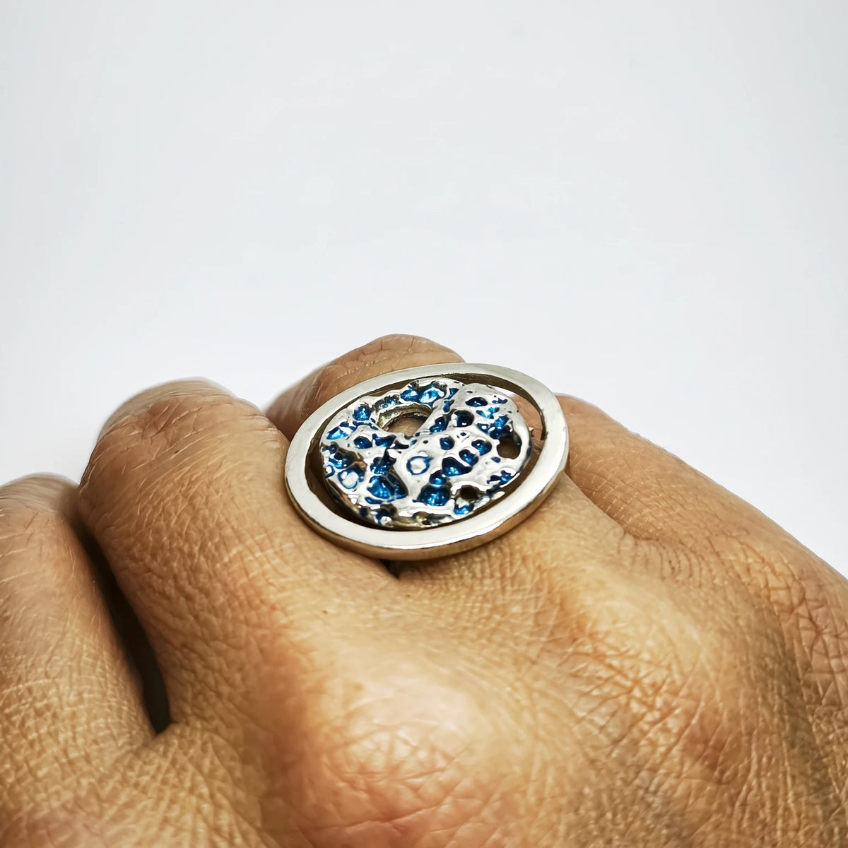woman wearing 925 sterling silver ring with the texture from a shell painted with blue. Design by Inês Almeida