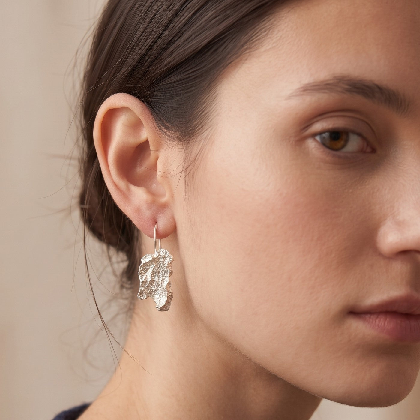 A female model wearing 925 sterling silver earrings with the texture from an algae. Design by Inês Almeida.