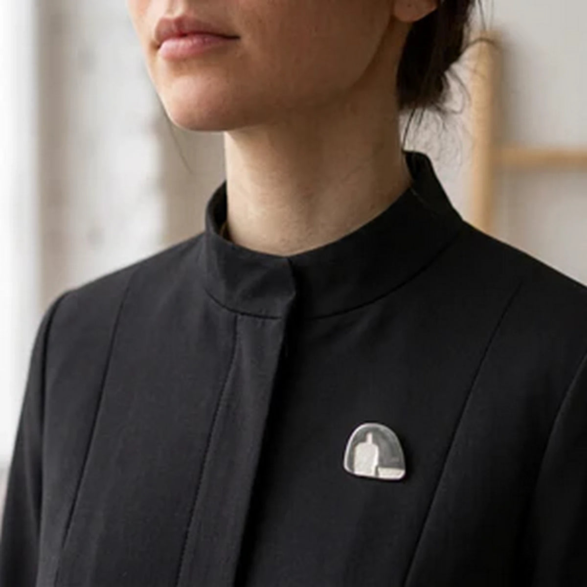 Woman wearing a black jacket with a double PIN bottle and plate - Handmade 925 Sterling Silver Pendant by Inês Almeida