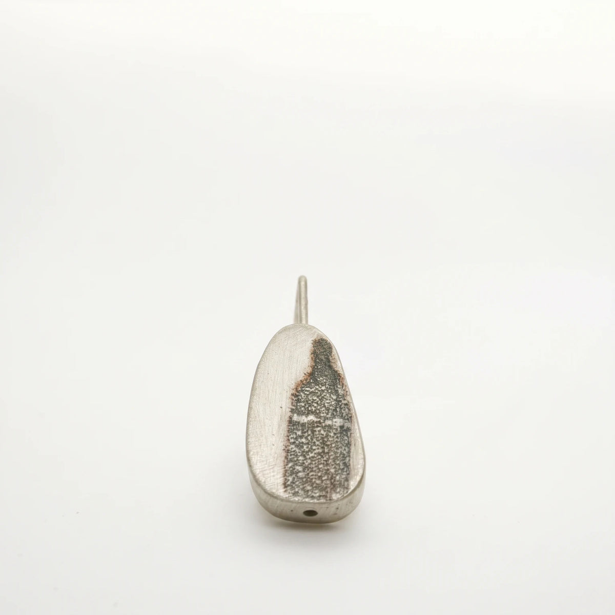 Sterling silver drop earring featuring a black bottle motif, front view, by Inês Almeida.