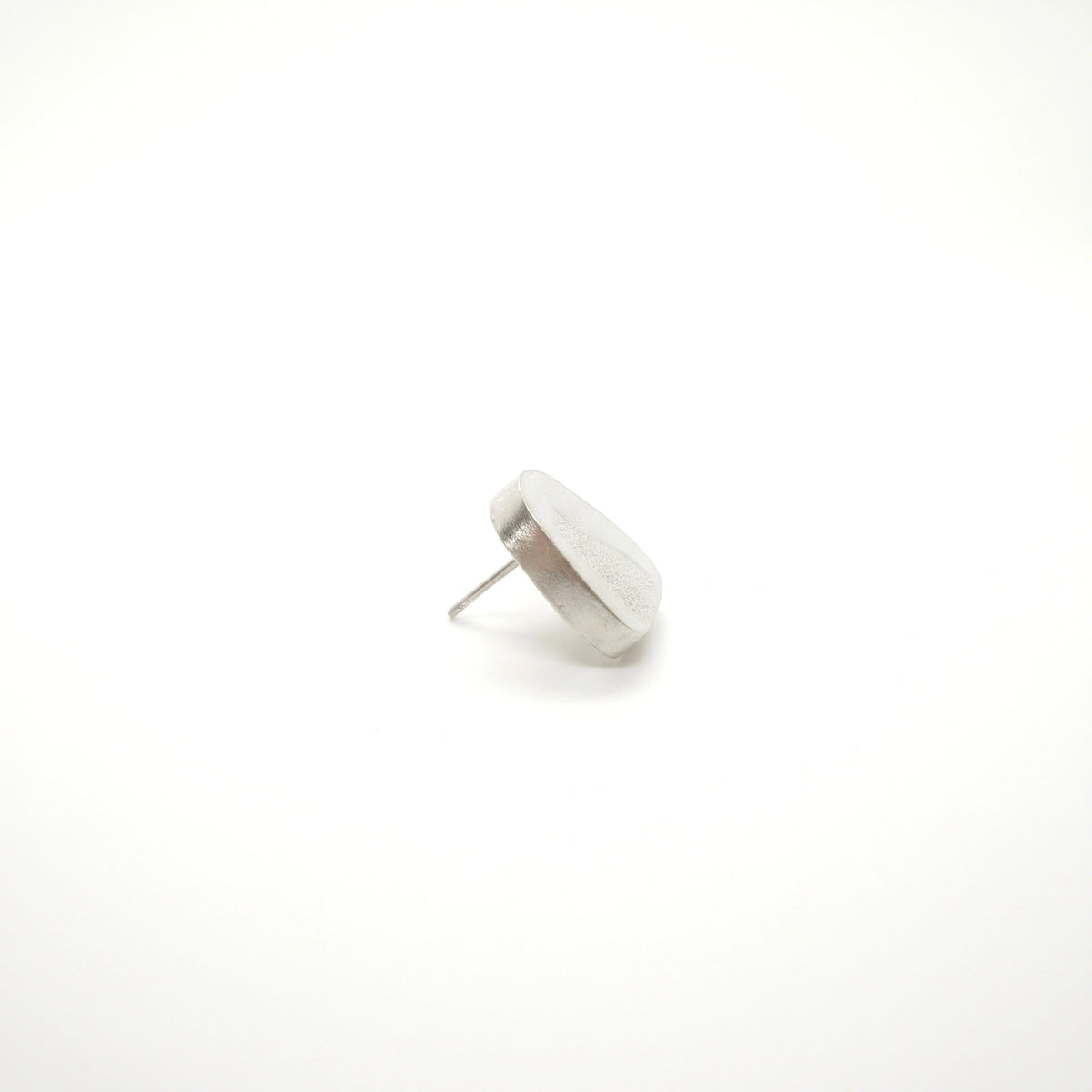 Profile view of a sterling silver earring featuring a bottle motif, showing its depth and post fastening, by Inês Almeida.
Show more lines