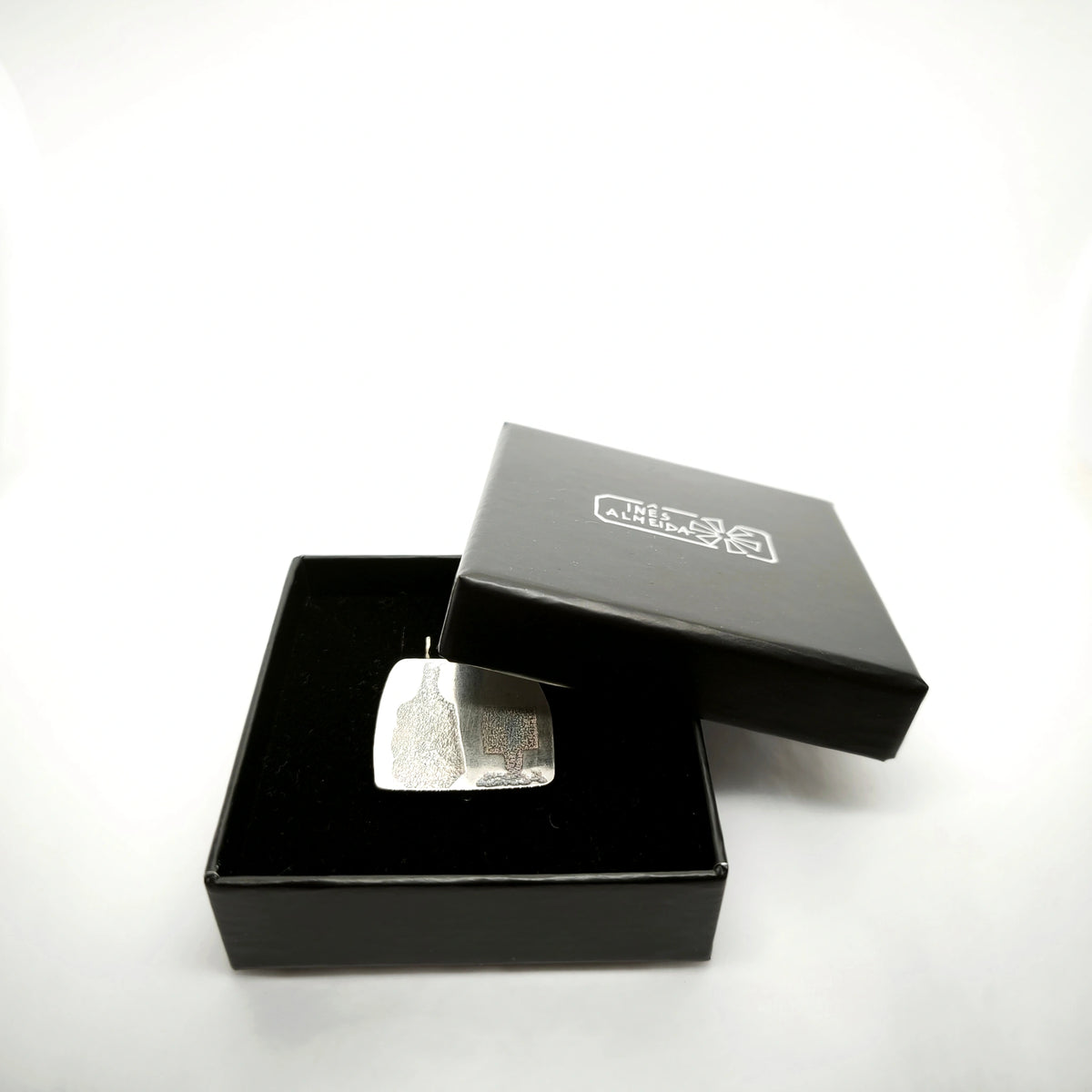 Sterling silver pendant featuring a bottle and glass motif presented in an open