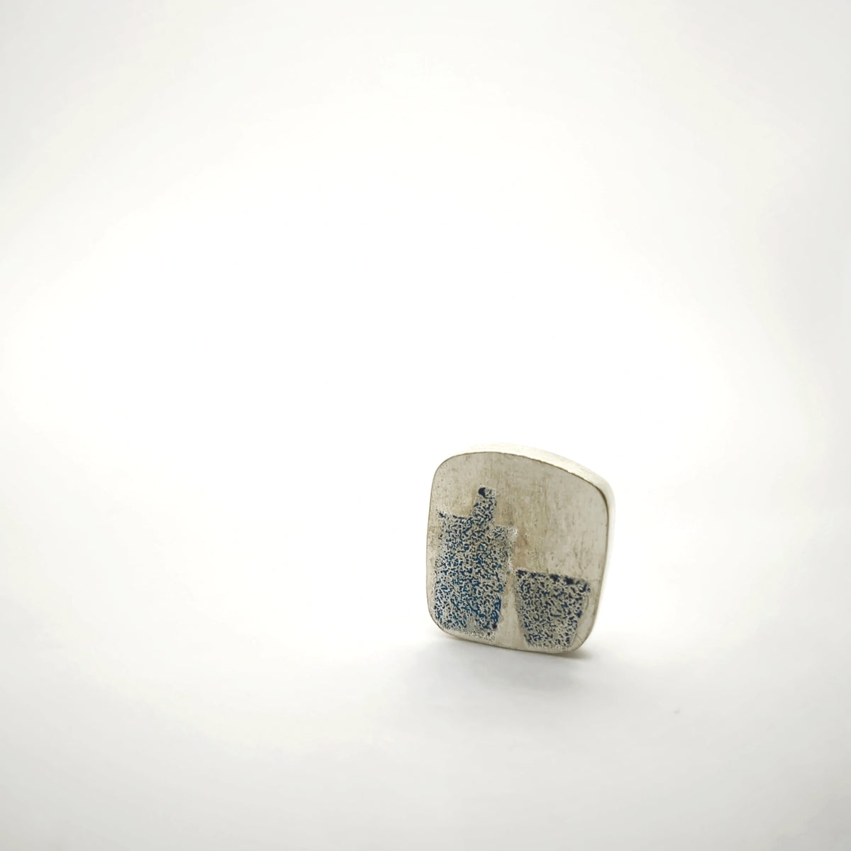 Sterling silver pin featuring a blue bottle and glass motif, front view.
Show more lines