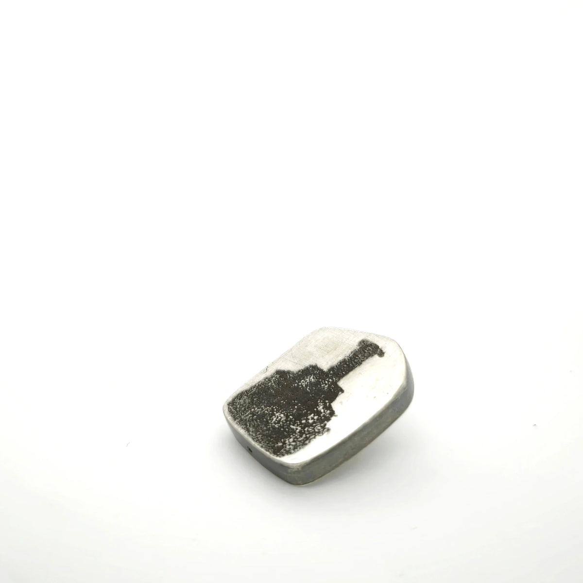 Side view of a sterling silver pin featuring a bottle motif.