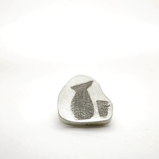 Sterling silver pin featuring a jug and glass motif, front view.