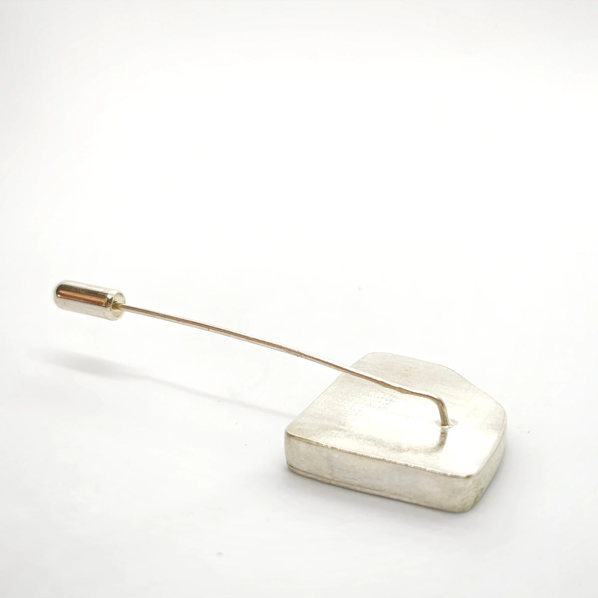 Reverse side of a sterling silver pin showing the handcrafted fastening mechanism.