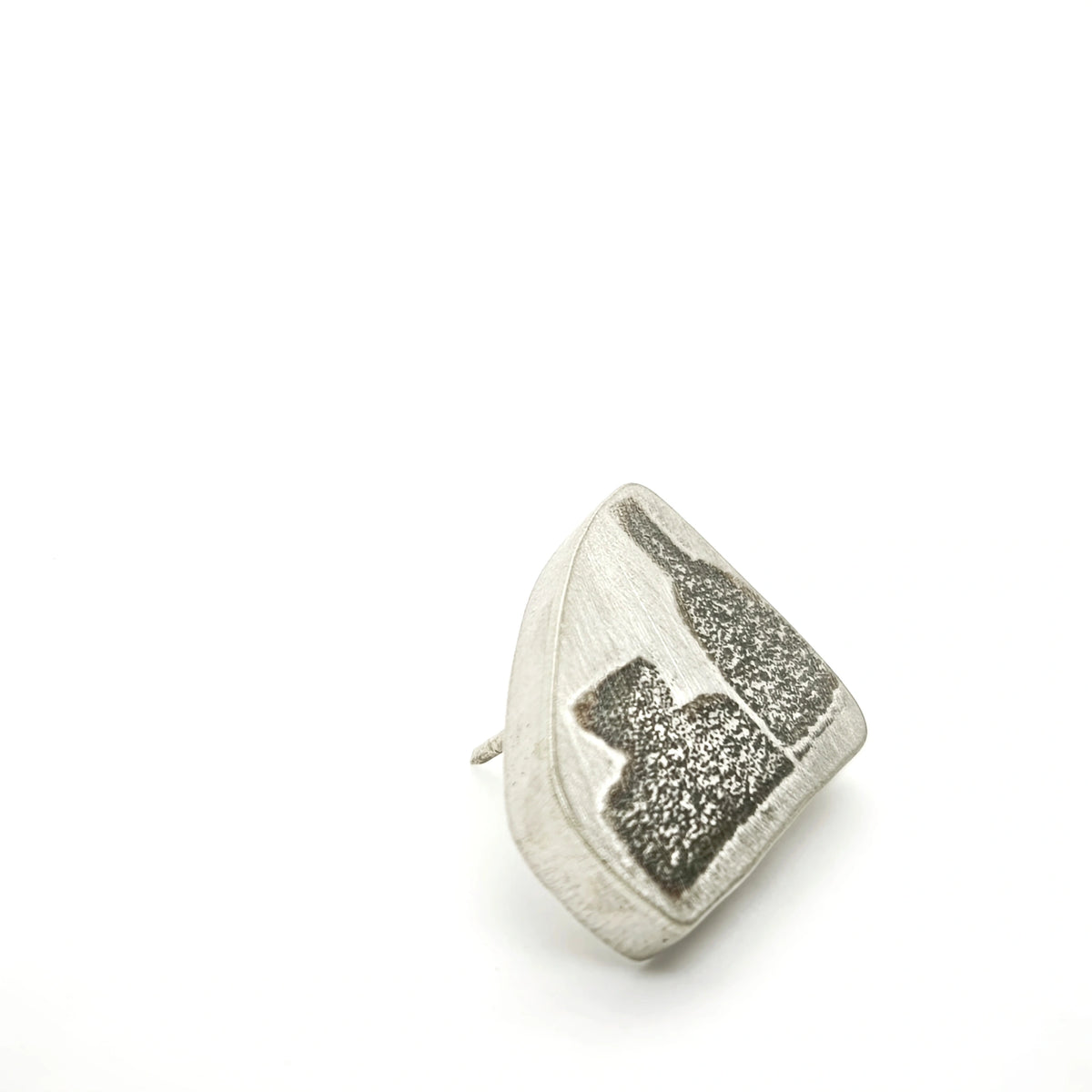 Angled view of a sterling silver pin featuring two bottle motifs.