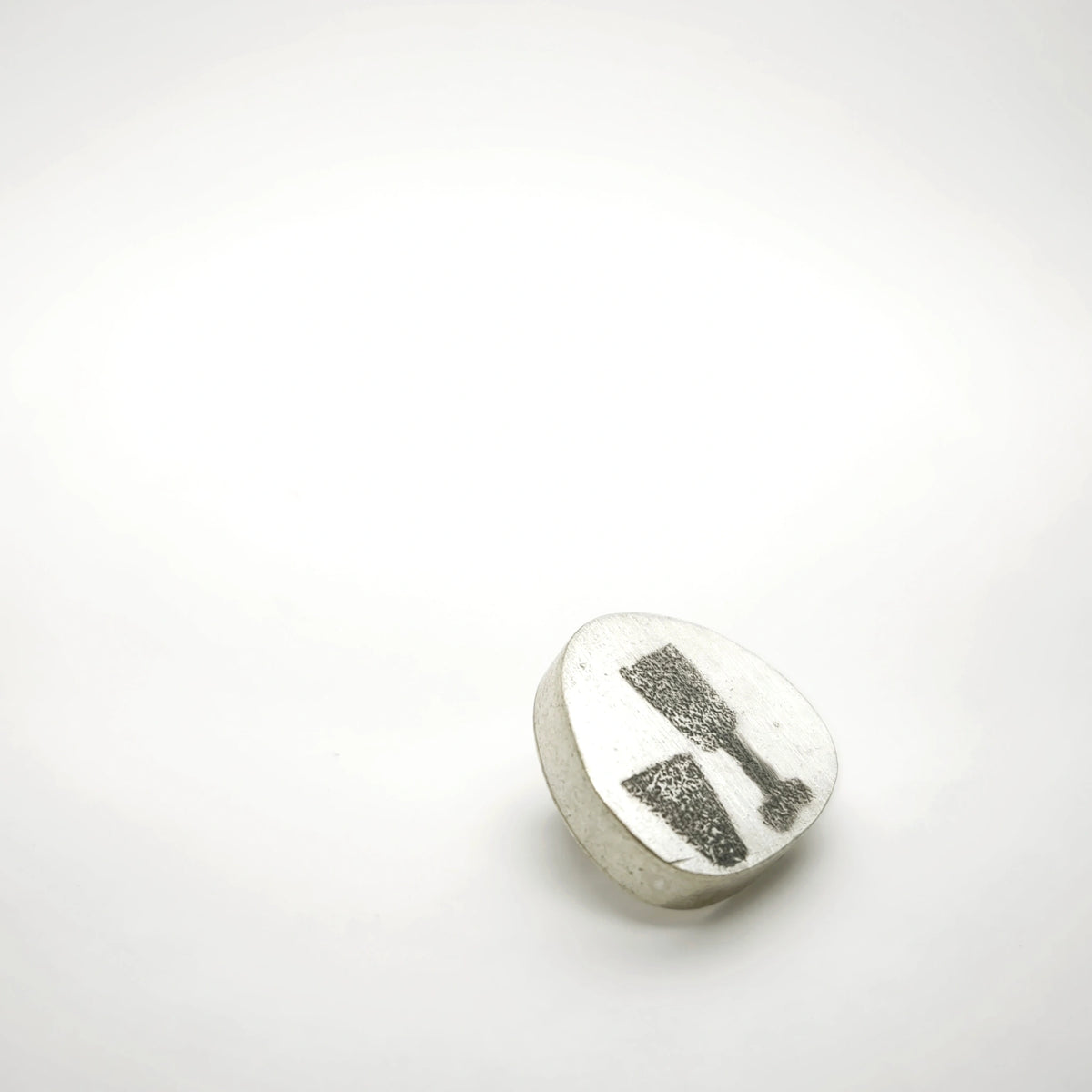 Angled view of a sterling silver pin featuring two glass motifs.