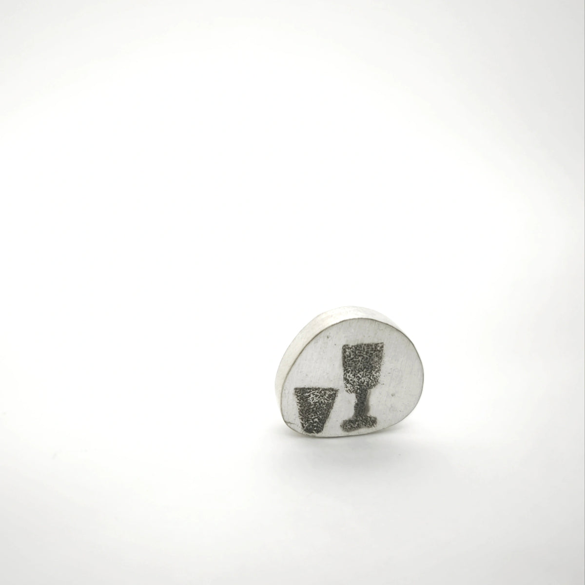 Sterling silver pin featuring two glass motifs, front view.
