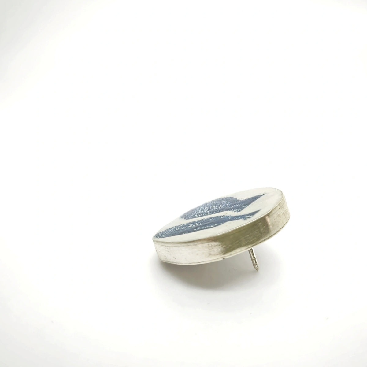 Angled view of a sterling silver pin featuring two blue Morandi-inspired jug motifs.