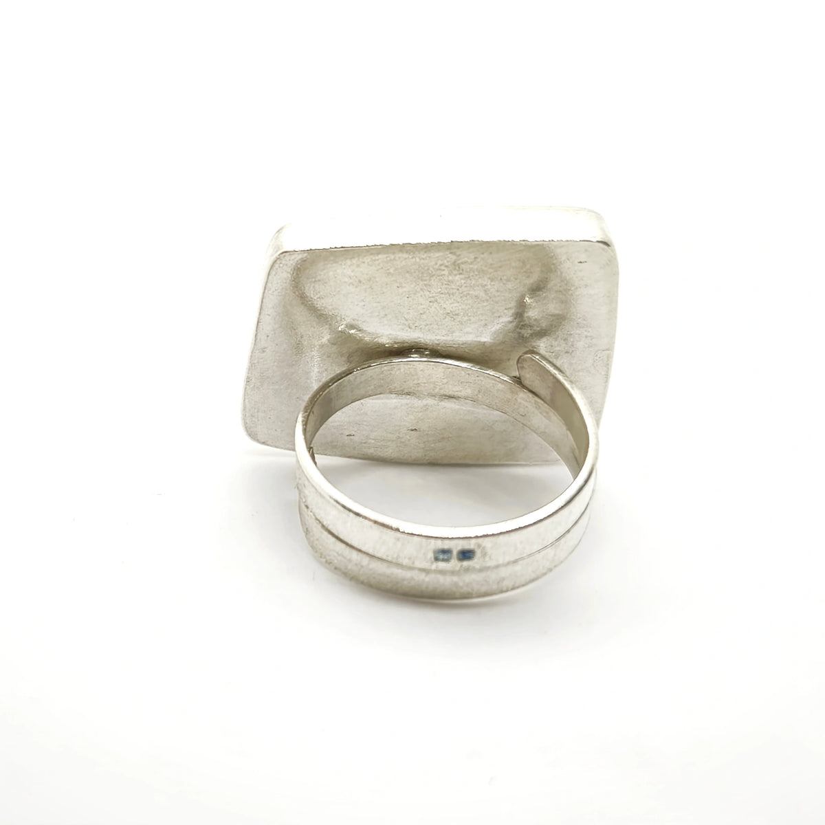 Profile view of a sterling silver ring featuring two jug motifs, showing its depth and adjustable band, by Inês Almeida.